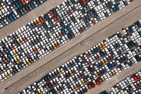 Aerial view of thousands of cars in a dealership inventory lot representing new car discount opportunities and finding the best month to buy a car