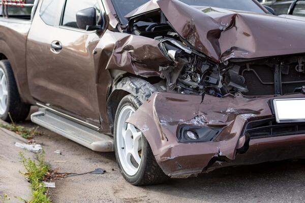 Brown truck with a crushed front end showing why salvage title insurance is restricted after a total loss