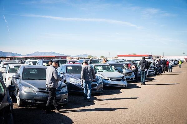Buyers walking and inspecting vehicles at an outdoor public car auctions Los Angeles lot showing cheap cars at auction Los Angeles available for bidding