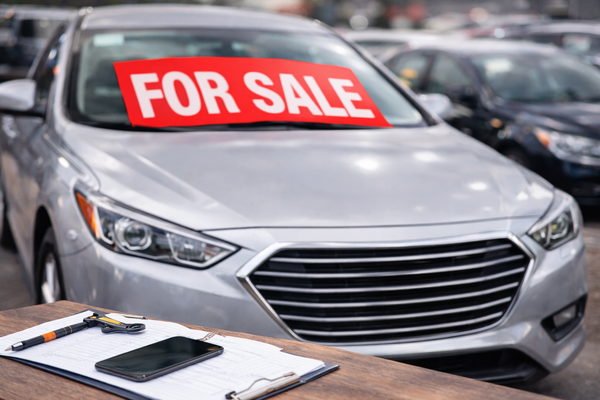 ვერცხლისფერი მანქანა 'გაყიდვისთვის' ნიშნით, demonstrating the buy and sell car strategy, a car resale opportunity using Kelley Blue Book car price evaluation tools