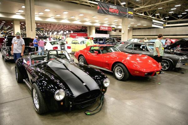 Classic muscle cars including a Cobra and Corvette on display at a classic car auction in Texas