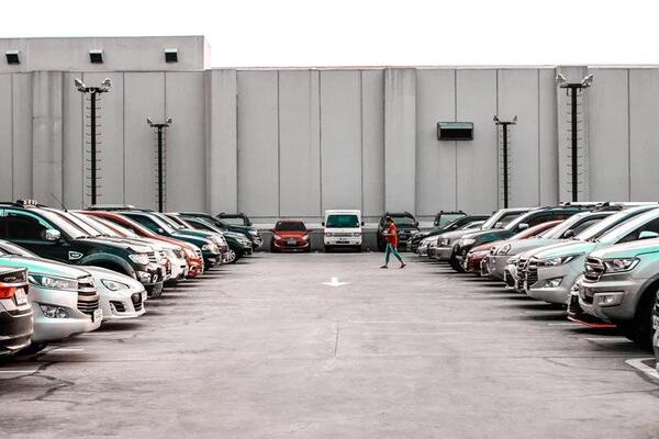 Person walking through a full dealership lot representing car buying season and knowing when to buy a new car to maximize discounts
